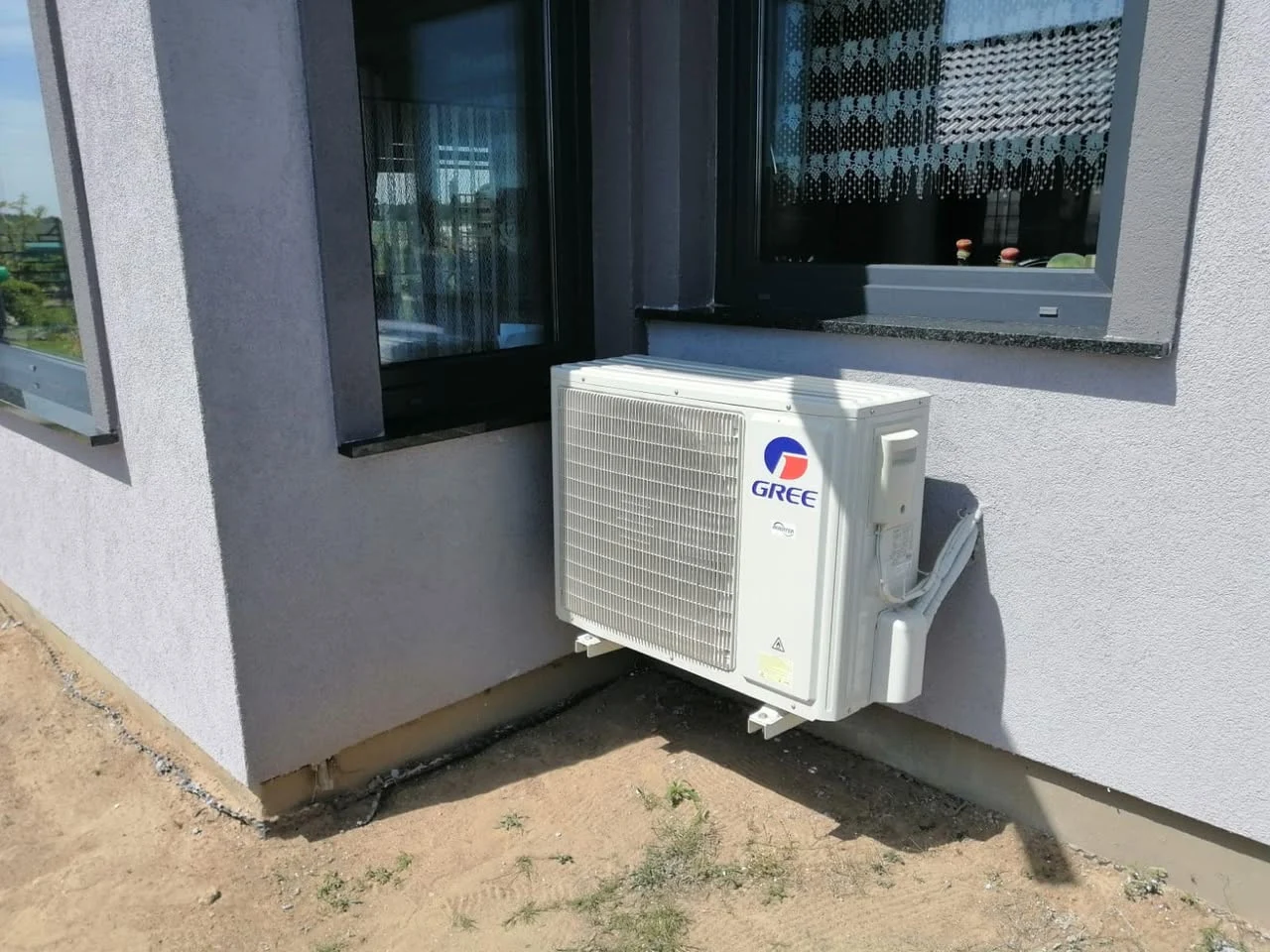 Klimatyzator Gree na wspornikach ściennych przy wyjściu na taras